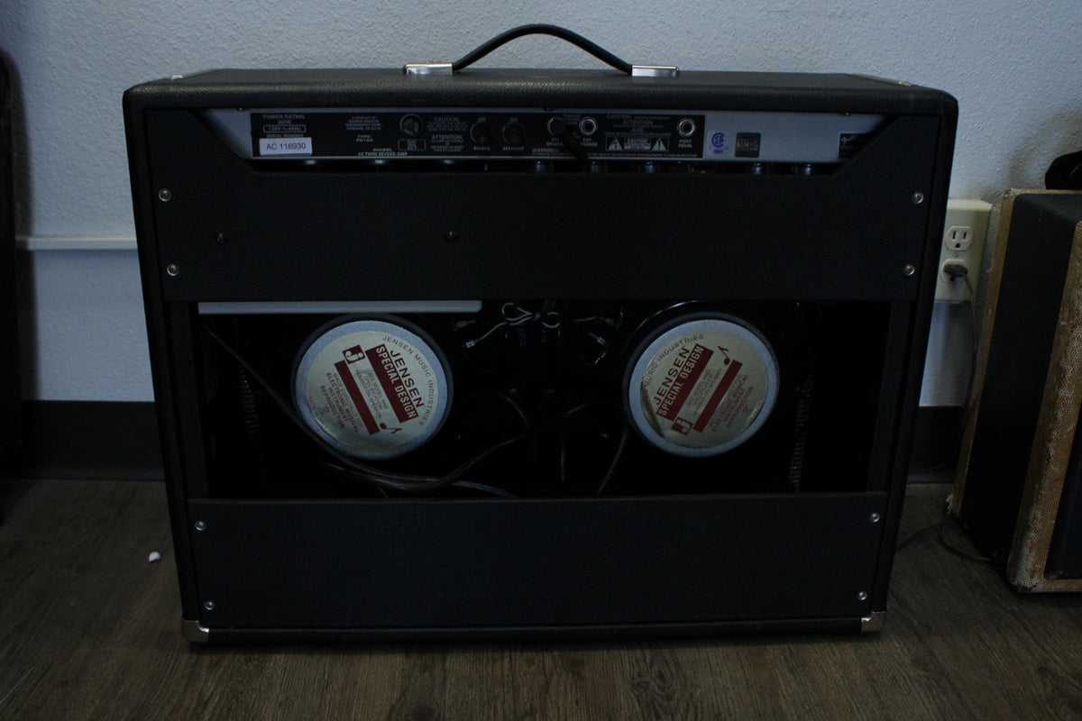 Rear view of a black combo amp, showing the control panel and two visible Jensen Special Design speakers.