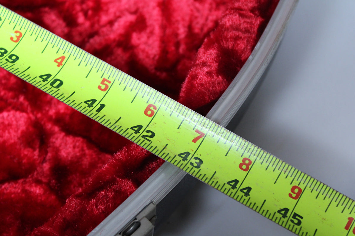 A yellow tape measure spans the red plush interior of the open case, showing measurements from 39 to 45 inches.