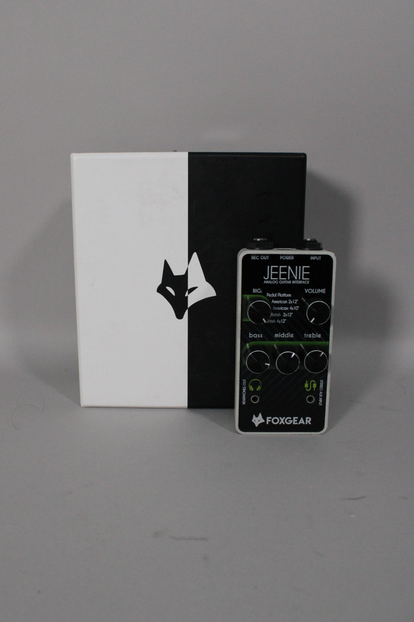 A black and white guitar interface pedal with six black knobs and a black and white box behind it.