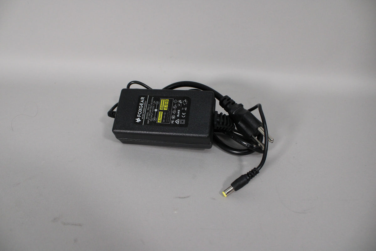 Black power adapter with a two-prong plug and a yellow-tipped barrel connector, viewed from above.