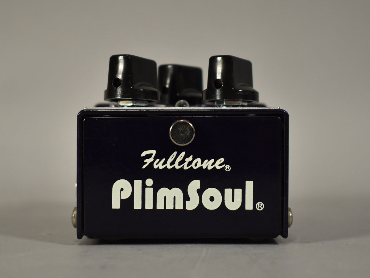 Dark purple pedal, viewed from the front, with three black control knobs visible on top and a silver screw on each side.