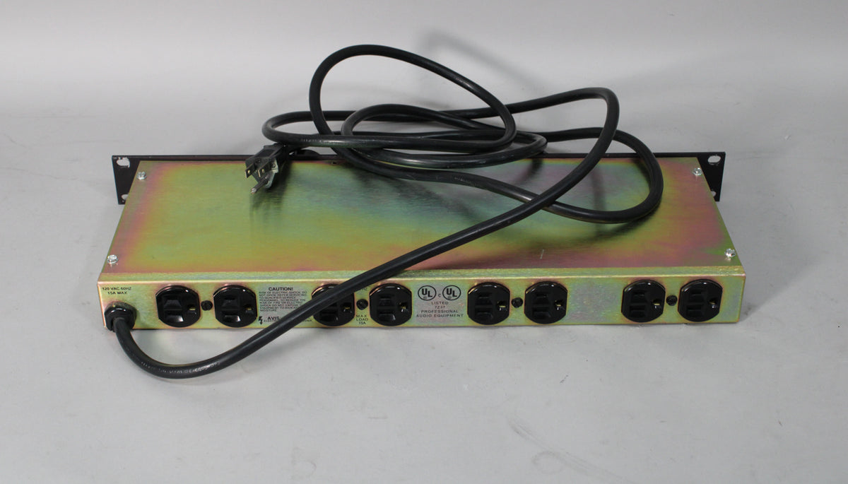 The power conditioner is seen from above, showing its gold-colored metal chassis and eight black AC outlets along the back.