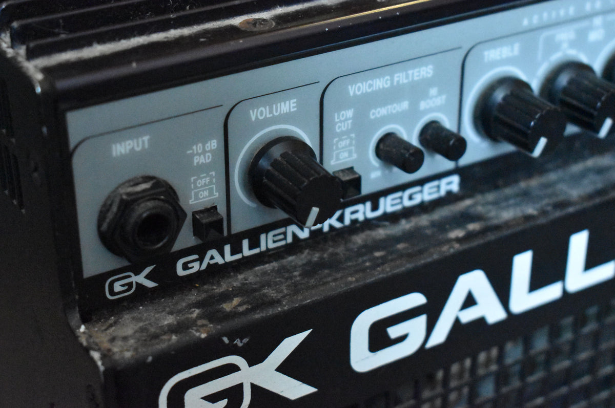 Close-up of the amp's dusty black control panel, showing the input jack, volume knob, and voicing filter switches.