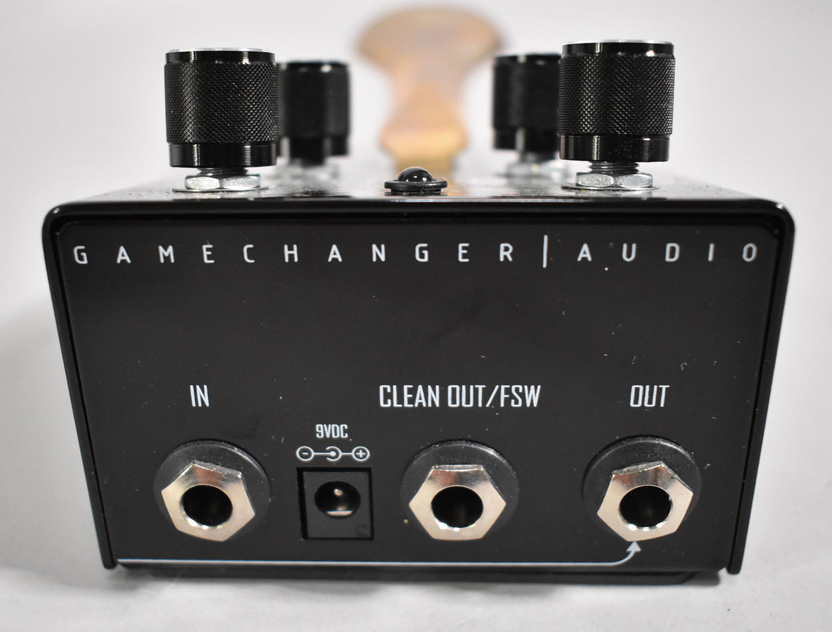 Rear view of a black pedal with three silver jack inputs, a 9VDC power input, and three black knurled control knobs on top.