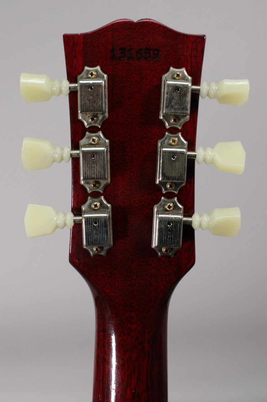 Rear view of the cherry-finished headstock and neck, showing six cream tuning pegs and chrome tuners with light aging.
