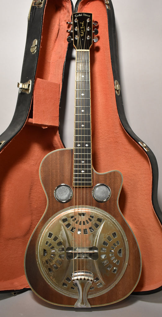 Full front view of a dark wood resonator guitar with a cutaway, two round mesh soundholes, and a tarnished gold resonator cone.