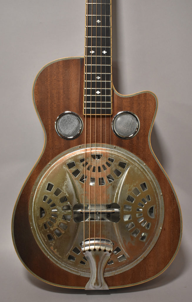 Full front view of a dark wood resonator guitar with a tarnished metal resonator cone and two round sound screens.