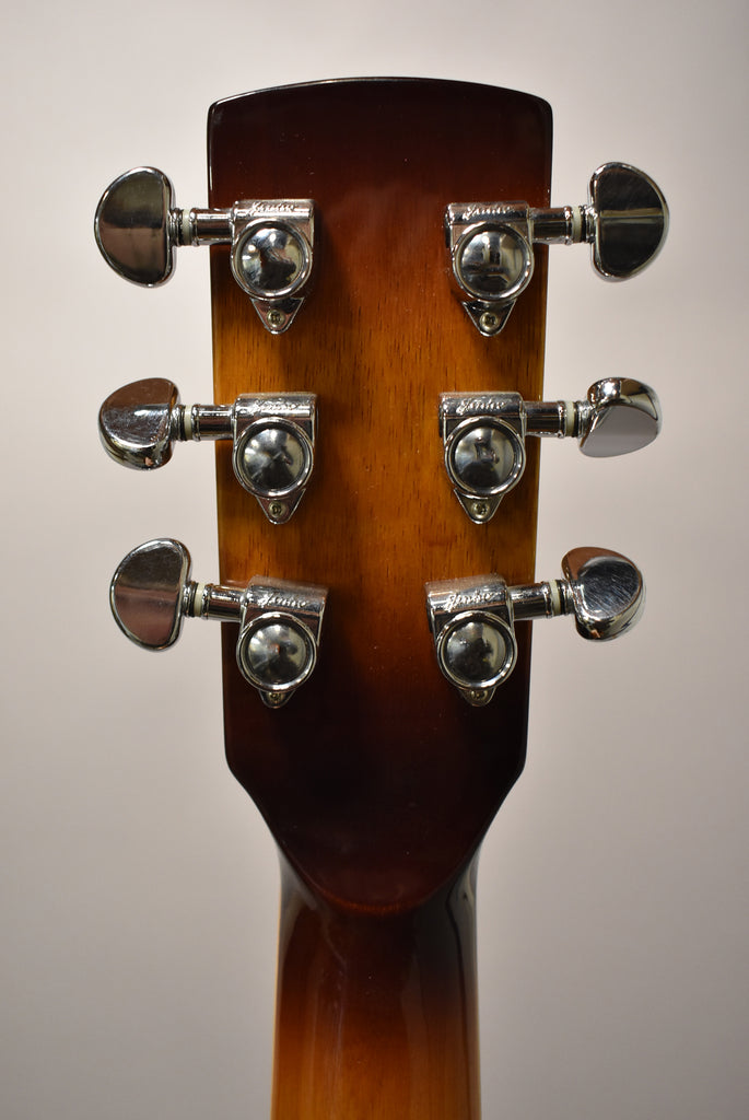 The back of the headstock and top of the neck, showing six chrome tuners on a glossy brown-to-amber sunburst finish.