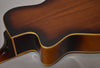 The resonator guitar's body, in a dark brown sunburst finish with light binding, is shown from the upper bout to the waist.