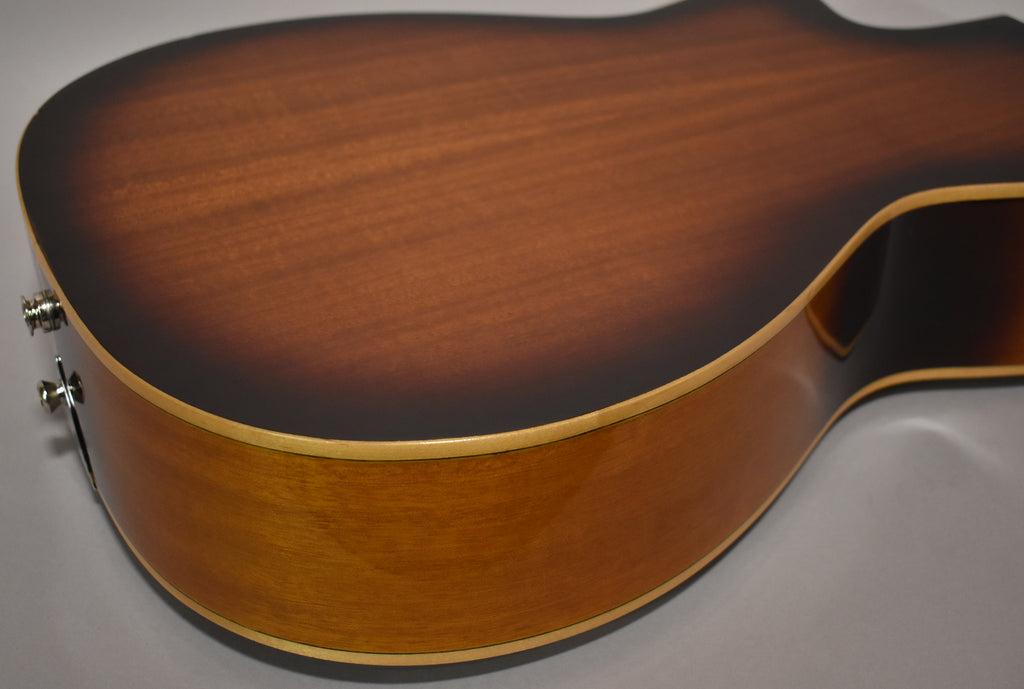 The lower bout of a sunburst resonator guitar, showing the dark brown back, light brown sides, and two chrome strap buttons.
