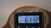 A close-up of a digital scale shows the guitar weighs 6 pounds, 11.2 ounces, with a faint brown background.
