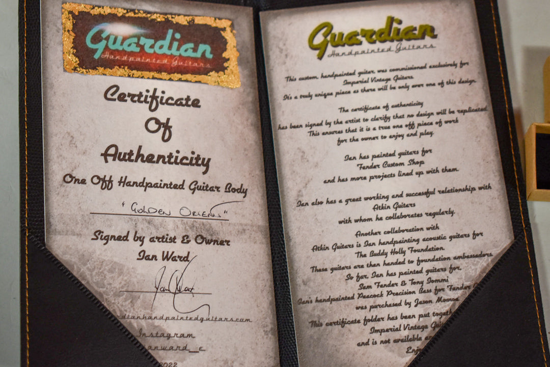 A black leather folder, open to show two pages of a "Certificate Of Authenticity" for a handpainted guitar.