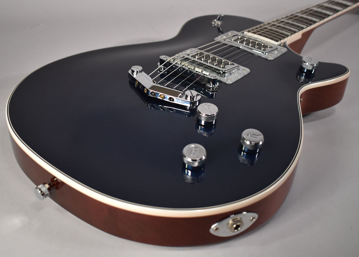 The dark blue electric guitar body, with cream binding and a brown side, is angled to show its chrome hardware and controls.