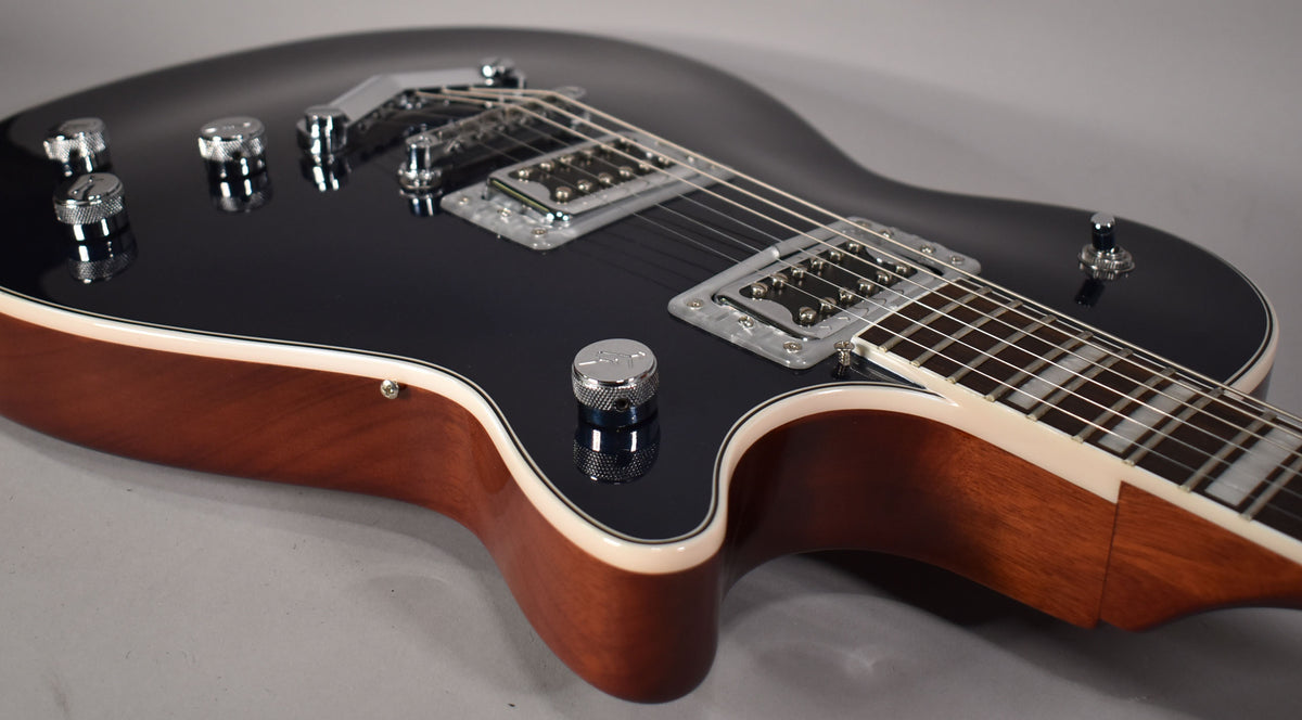 Close-up of the guitar body, showing the glossy dark grey top, cream binding, natural wood sides, and chrome hardware.