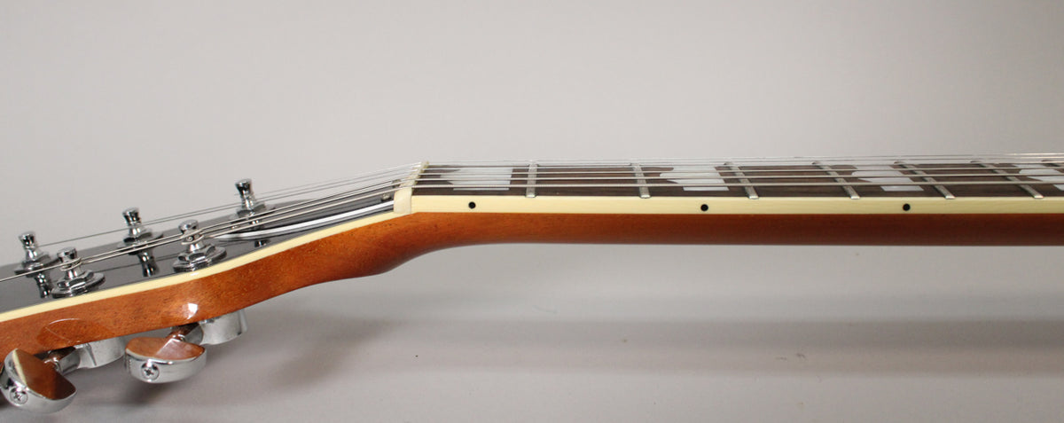 The guitar's neck and headstock are shown from the side, with a dark brown finish, cream binding, and chrome tuners.