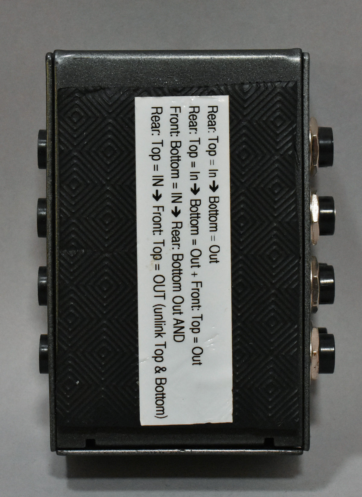 The patchbay module is viewed from above, showing its textured black top panel and four pairs of gold-ringed jacks.