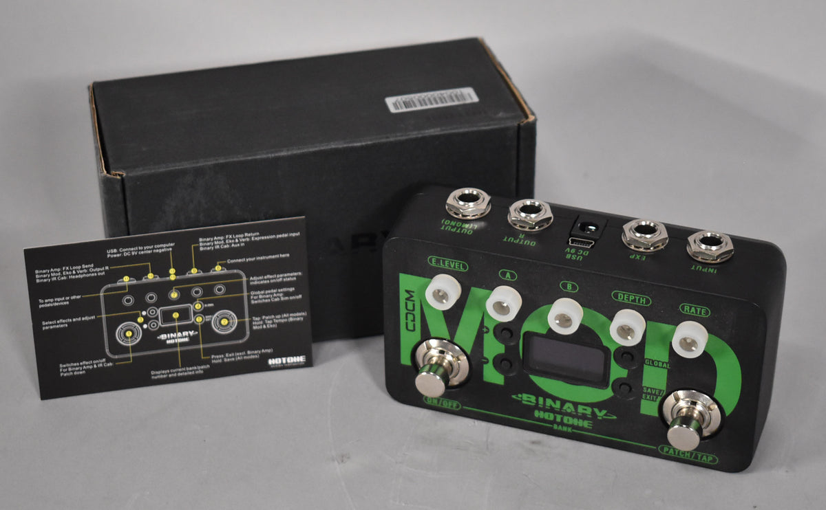 A black multi-effect pedal with green graphics, silver footswitches, and clear knobs, shown with its black box and manual.