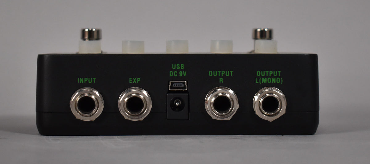 The rear of the black pedal shows four 1/4" jacks, a mini-USB port, and a DC 9V power input, all labeled in green.