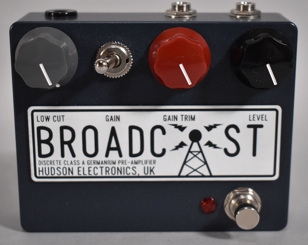 A dark grey pedal with a white label, three large control knobs (grey, red, black), a toggle switch, and a footswitch.