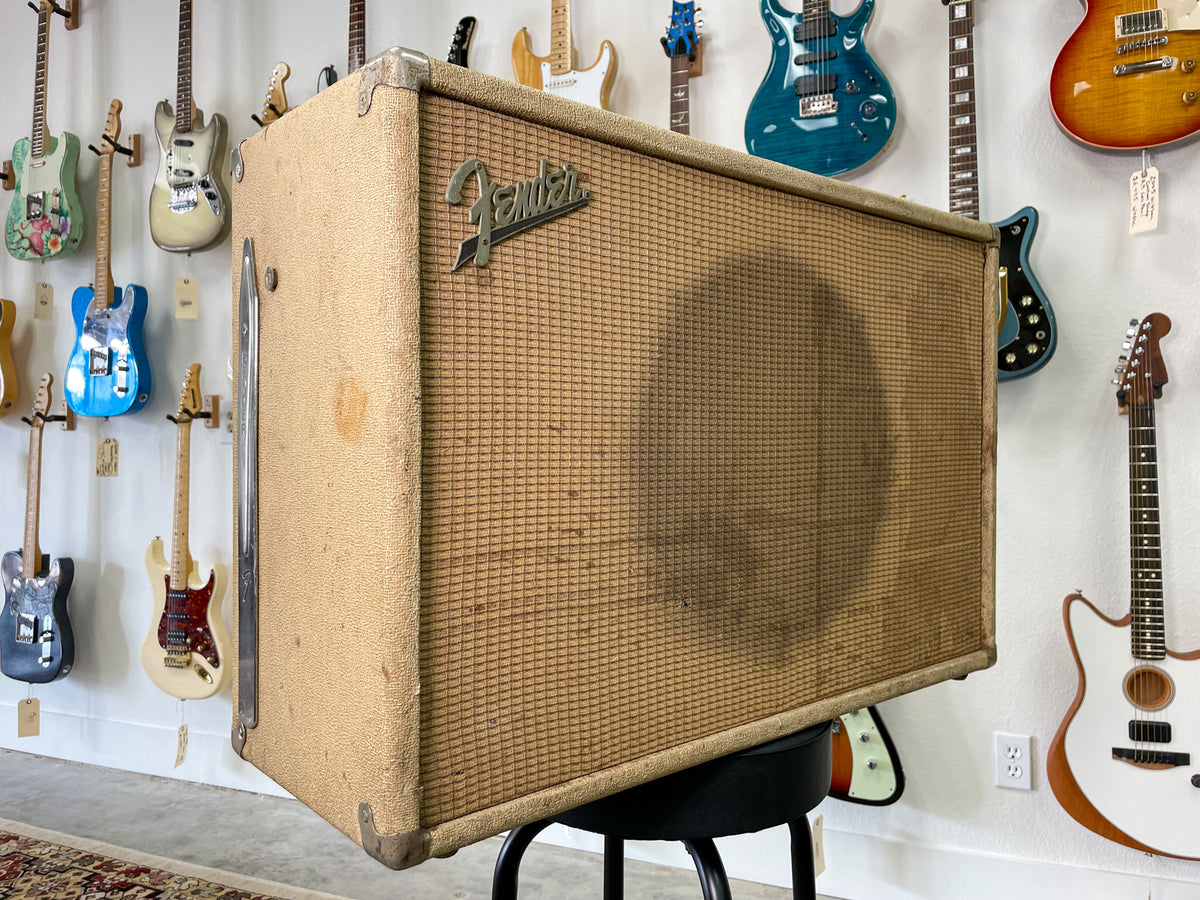 The blonde speaker cab is angled, showing its textured front grille with a dark stain and a chrome side handle.