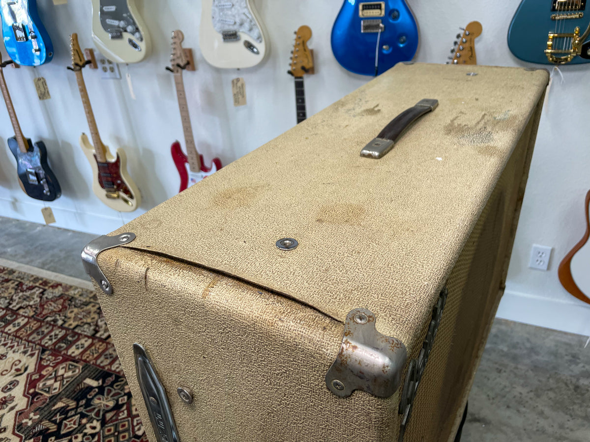 Top-down view of a blonde speaker cab with a brown handle, metal corner protectors, and visible wear and stains on the top.