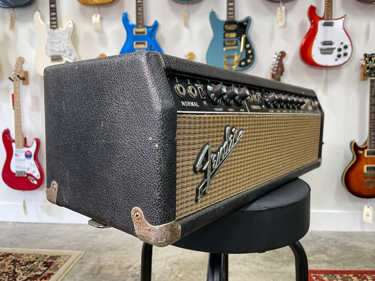 Black tolex amp head, angled from the left, showing the textured finish, tarnished corner protectors, and a full view of the control panel.