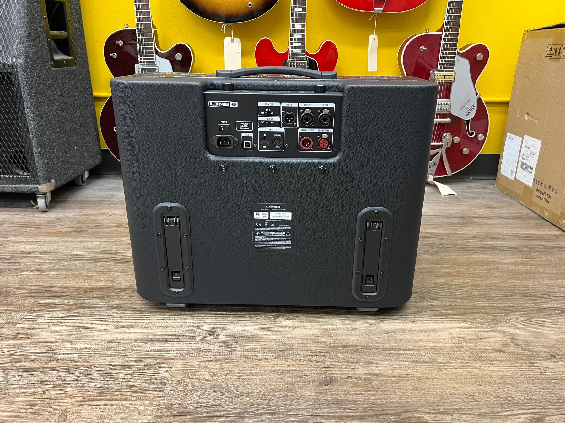 Rear view of the black Line 6 Powercab 112 Plus amp, showing its top handle, power input, and various XLR and USB ports.