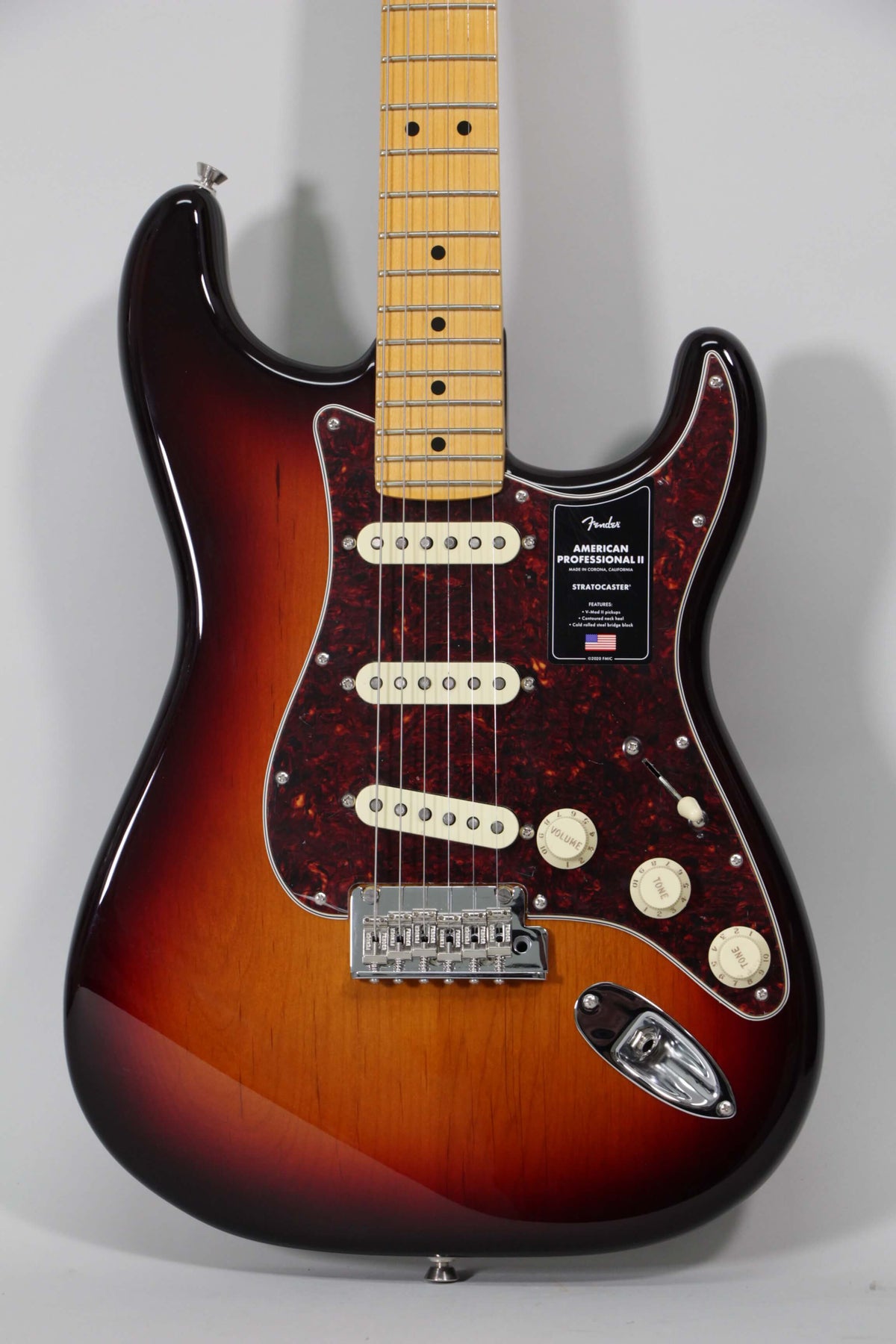 Full front view of a sunburst Stratocaster with a tortoiseshell pickguard, maple fretboard, three single-coil pickups, and chrome hardware.