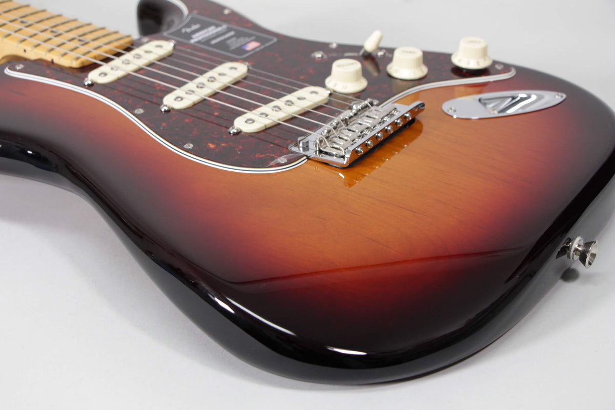 The glossy sunburst Stratocaster body, with a tortoiseshell pickguard, three cream single-coil pickups, and chrome hardware, is angled right.