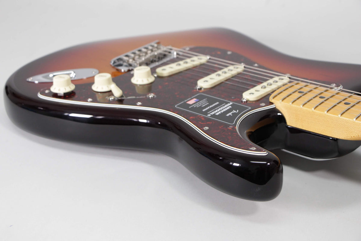 Close-up of a sunburst Stratocaster body, showing the lower bout, tortoise pickguard, cream pickups, and control knobs.