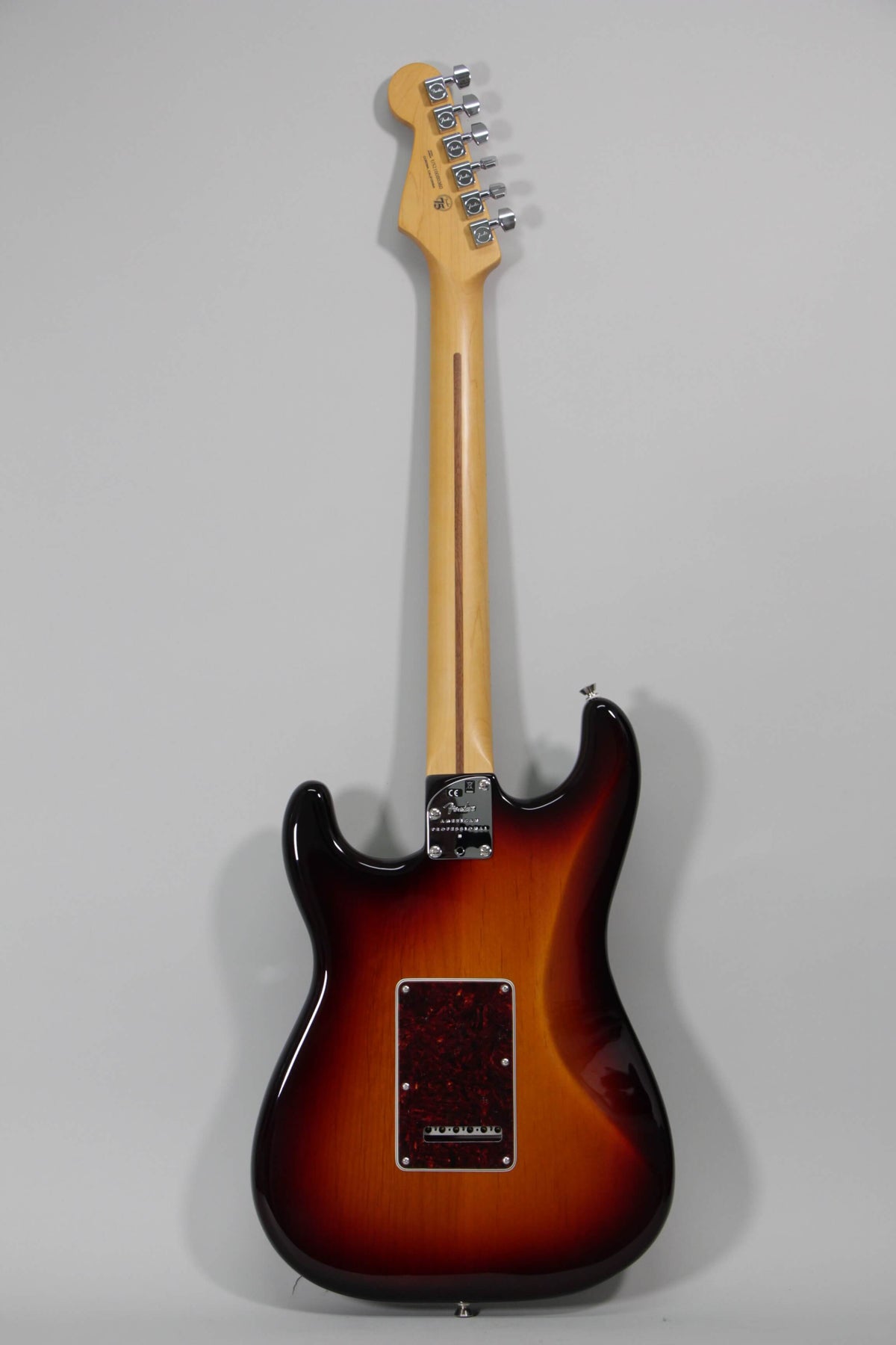 Full rear view of a sunburst Stratocaster with a maple neck, chrome tuners, and a tortoiseshell tremolo cover.