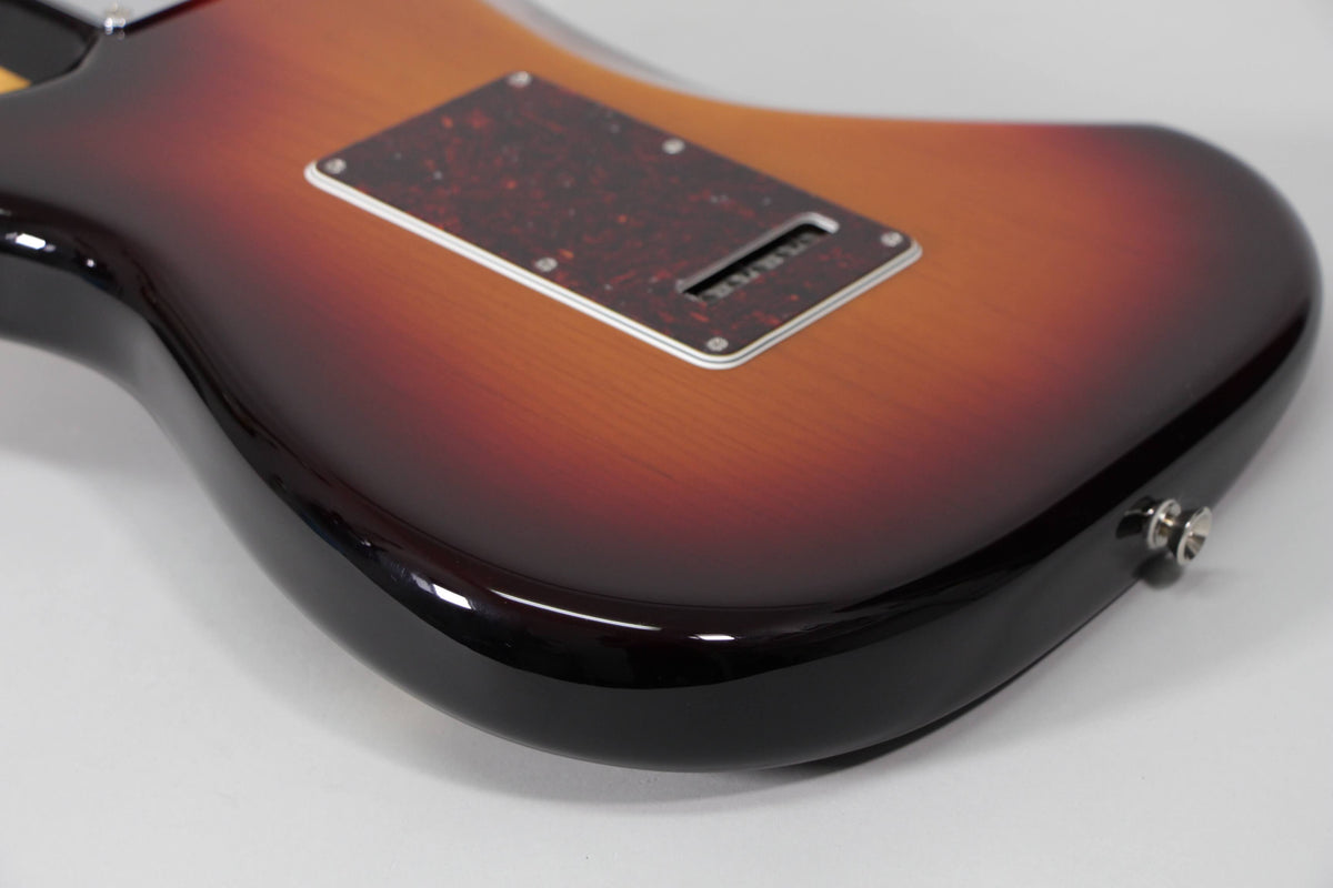 The sunburst Stratocaster body, viewed from the back, shows a tortoiseshell tremolo cover and a chrome output jack.