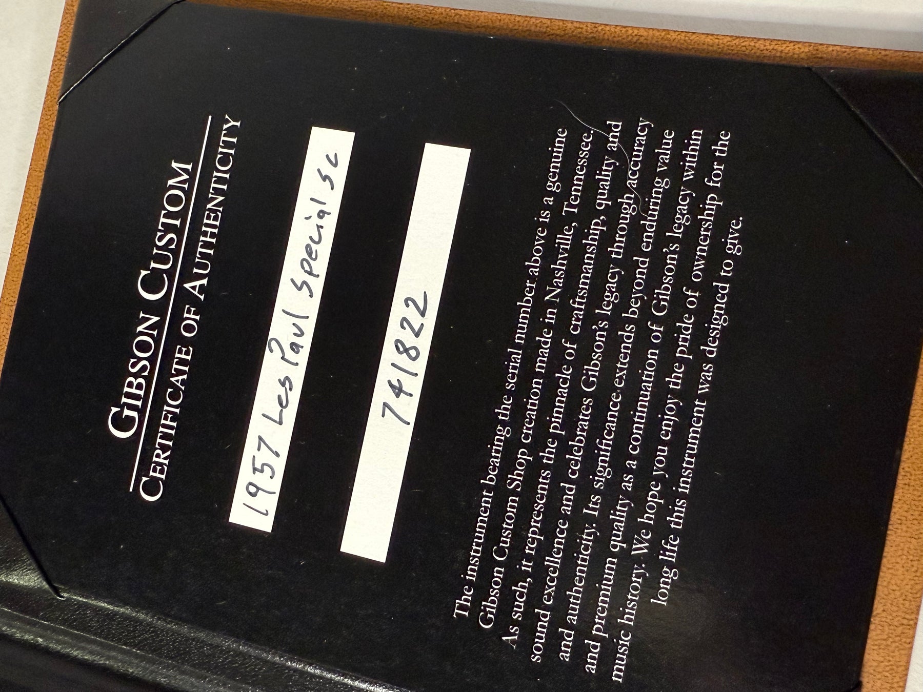 Close-up of the Gibson Custom Certificate of Authenticity, showing the black card with white text and handwritten details.