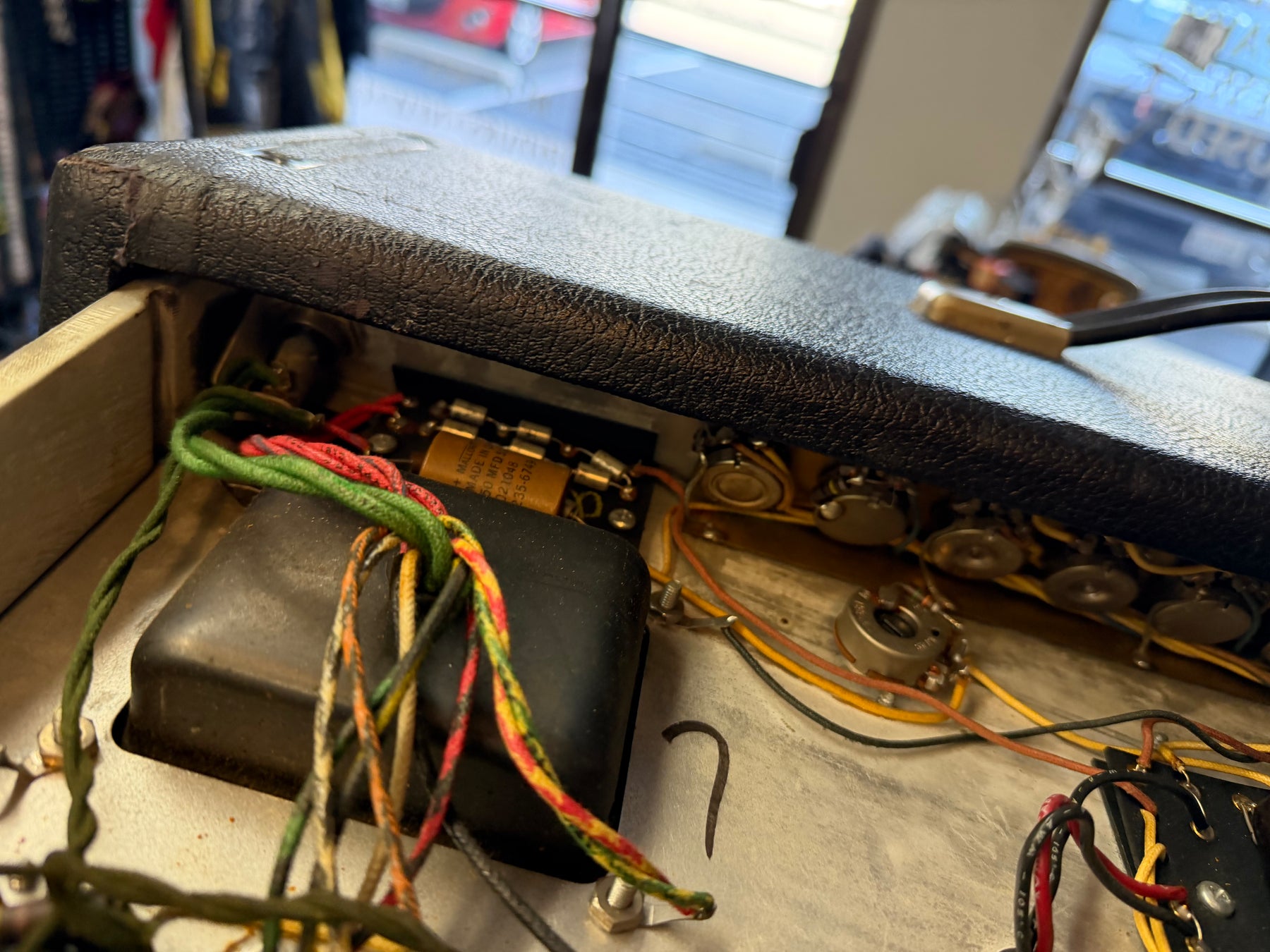 Close-up of the amp's open chassis, revealing internal wiring, capacitors, and the backs of several control pots.