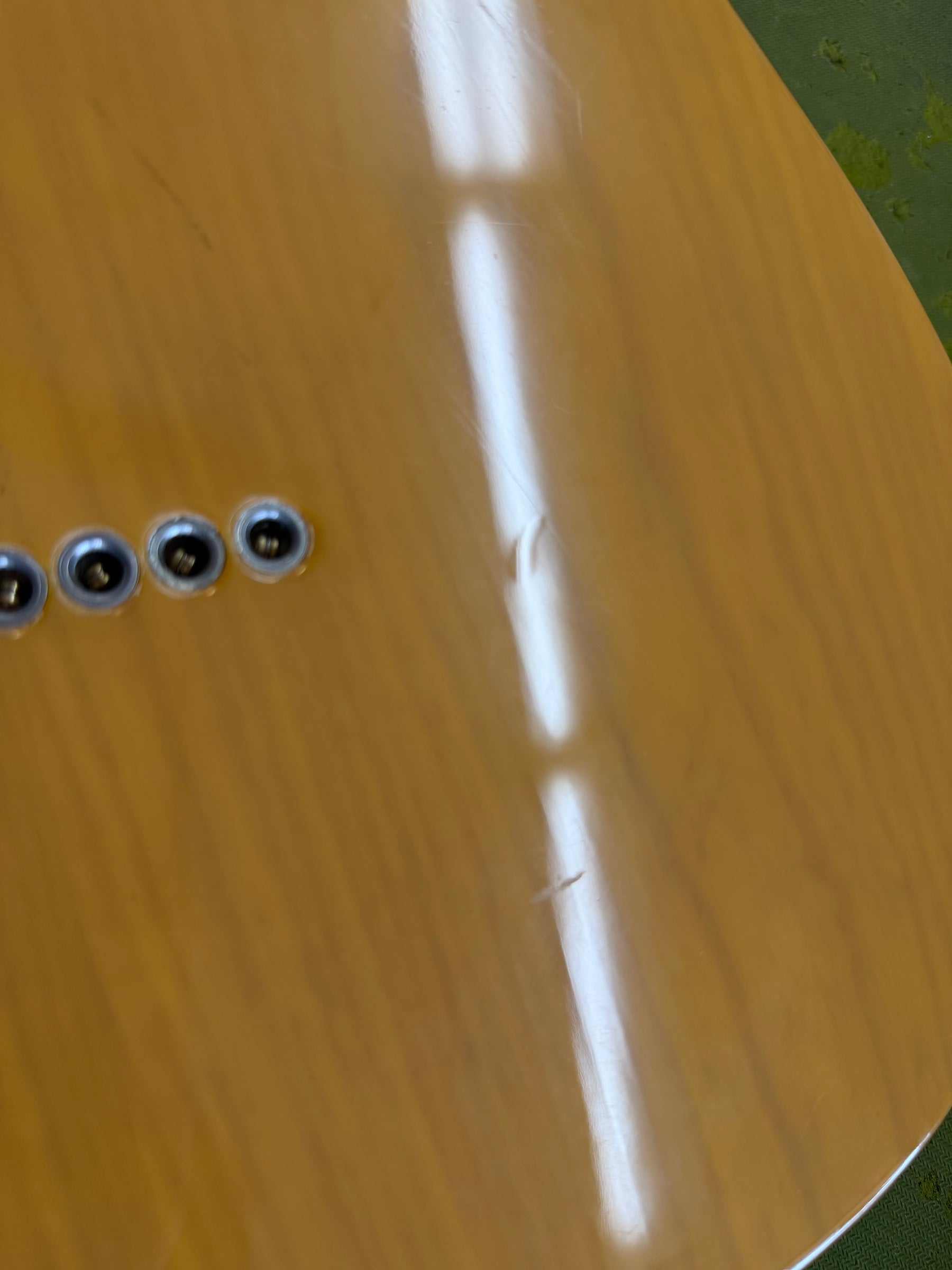 Close-up of the butterscotch blonde body, showing string ferrules and two notable dings on the back.