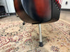 The bass's lower bout, in tobacco sunburst, rests on a single silver leg with a black rubber foot, viewed from below.