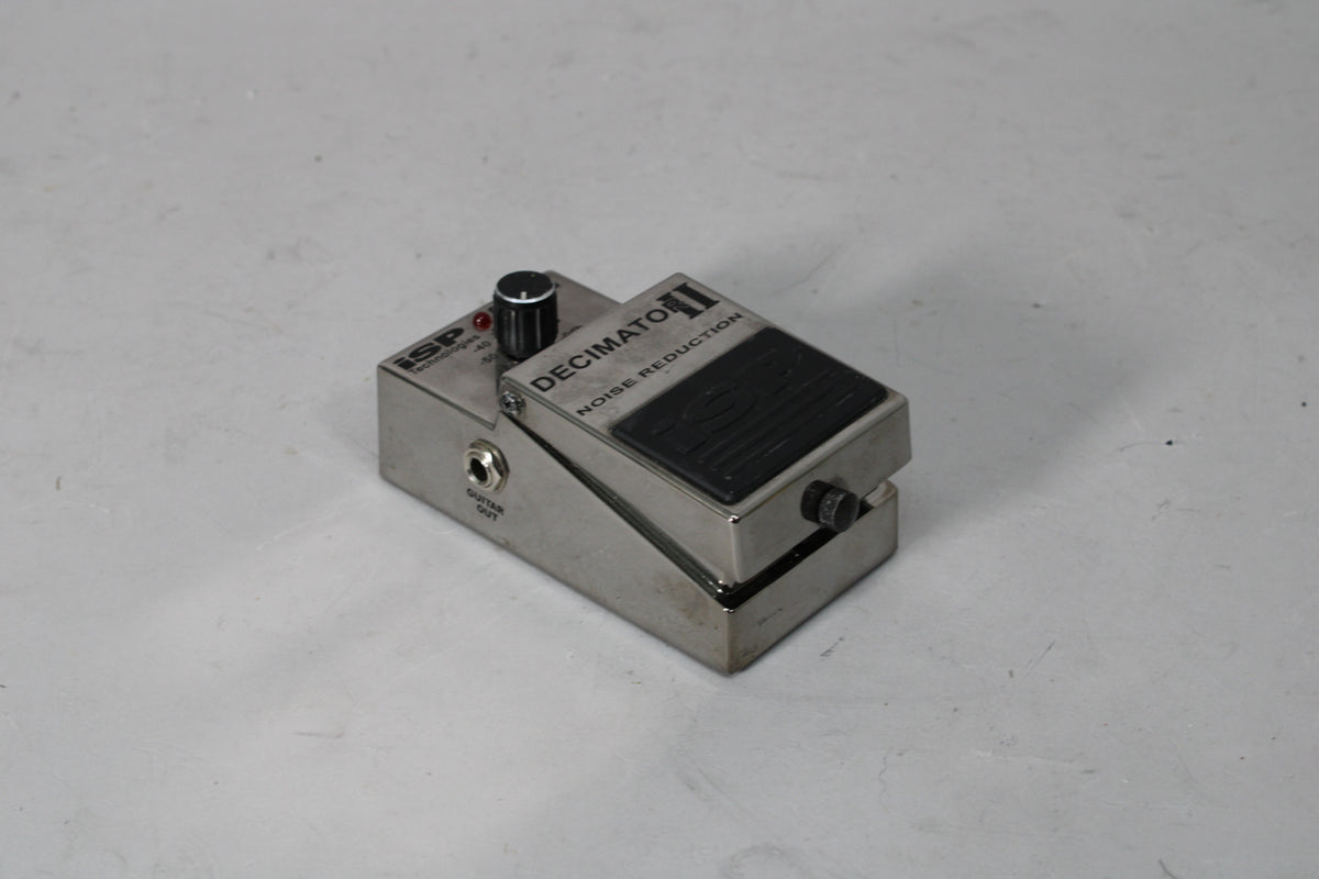 A brushed metal guitar pedal, angled from the front-left, showing the single black knob, red LED, and "GUITAR OUT" jack.