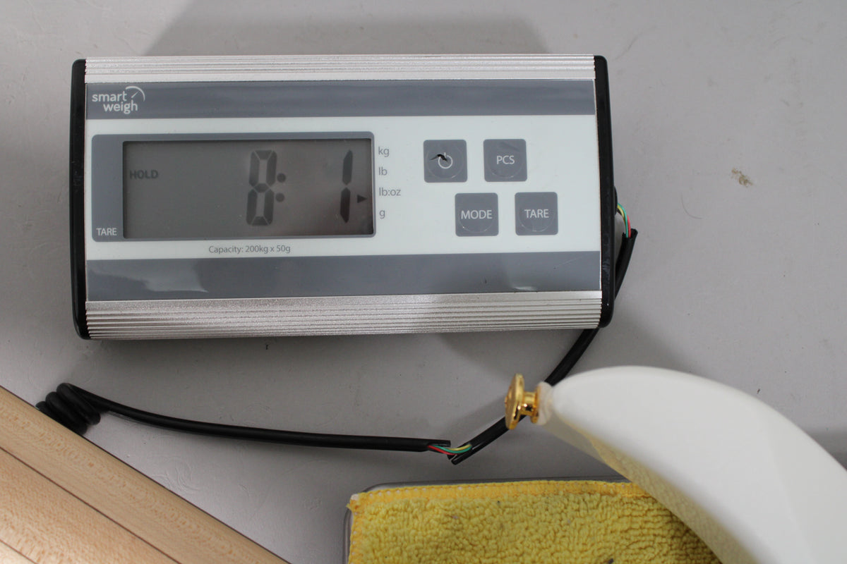 A digital scale displays "8.1" with a white guitar body and gold strap button partially visible on the right.