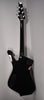 The back of the black guitar shows a glossy finish, chrome tuners, a neck plate, and two control cavity covers.