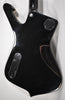 The guitar's glossy black back shows light surface scratches, with two silver control plates and a neck plate.