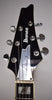 The black gloss headstock with white binding features chrome tuners, a silver truss rod cover with a signature, and block inlays.
