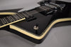 Close-up of the glossy black guitar body, showing cream binding with abalone purfling, a chrome toggle switch, and two humbucker pickups.