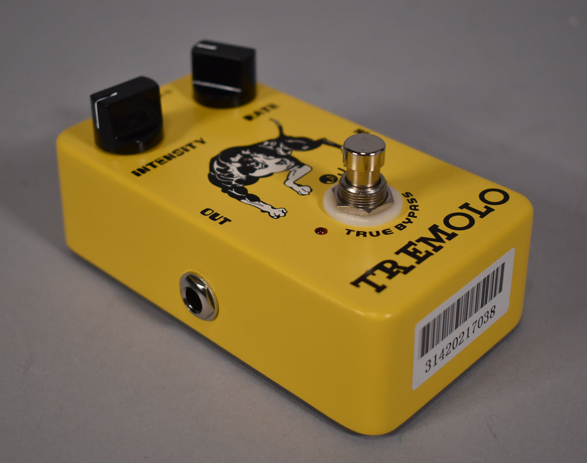 Bright yellow pedal with two black knobs, a silver footswitch, and a black dog graphic, viewed from the front right.