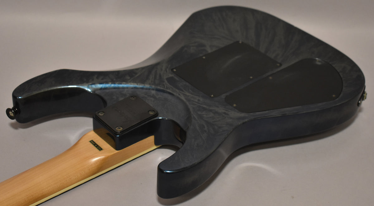 The back of a blue swirl electric guitar, showing the neck joint, two black control cavity covers, and some light surface wear.