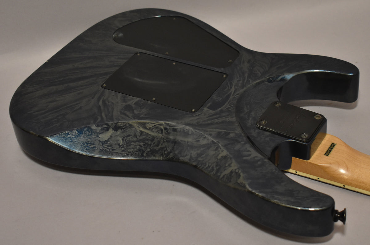 The guitar's back shows a blue swirl finish with two black control cavity covers, a natural maple neck, and a black strap button.