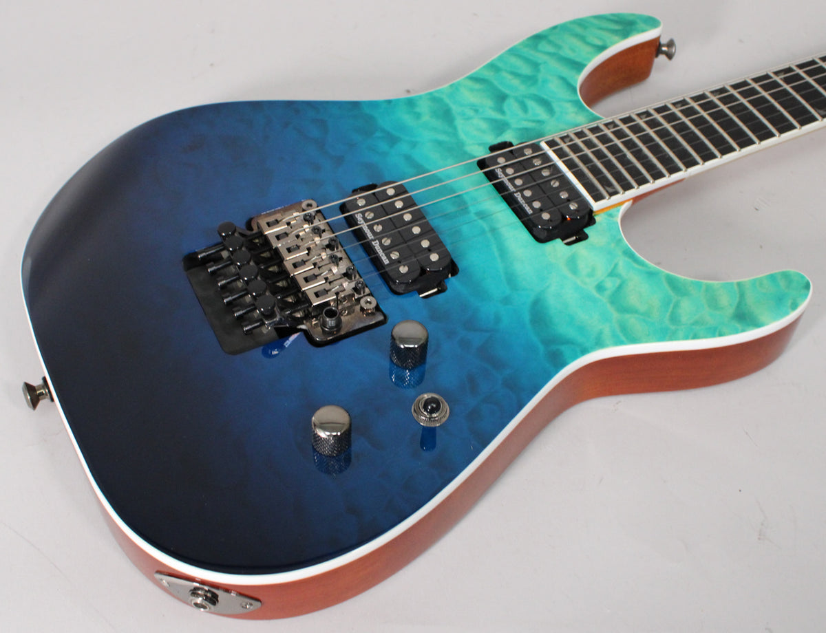 The electric guitar's body, in a blue-to-green fade with quilted maple, shows a Floyd Rose bridge and two humbucker pickups.