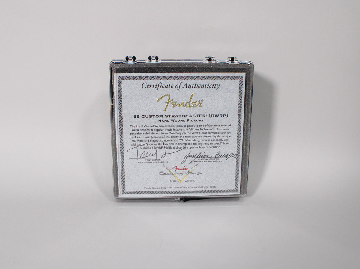 A clear plastic case with a certificate of authenticity for hand-wound pickups, signed by Josefina Campos, is shown from above.