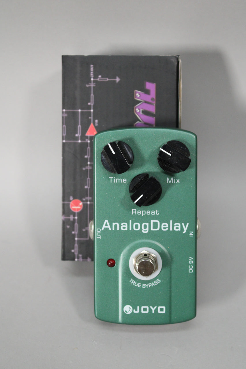 A top-down view of a metallic green pedal with three black control knobs, a red LED, and a silver footswitch.