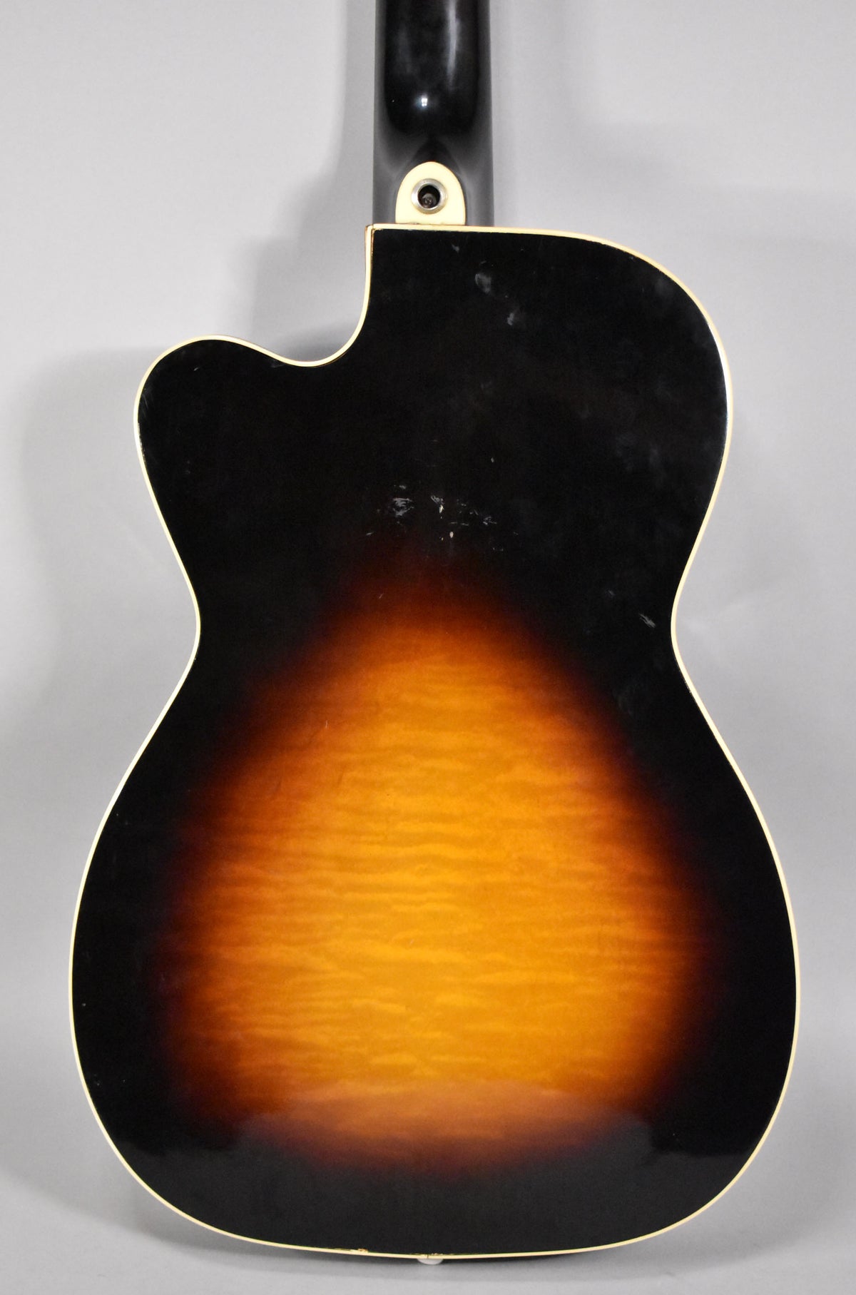The guitar's sunburst back, with a flame maple center, shows binding and finish wear near the neck joint and lower bout.