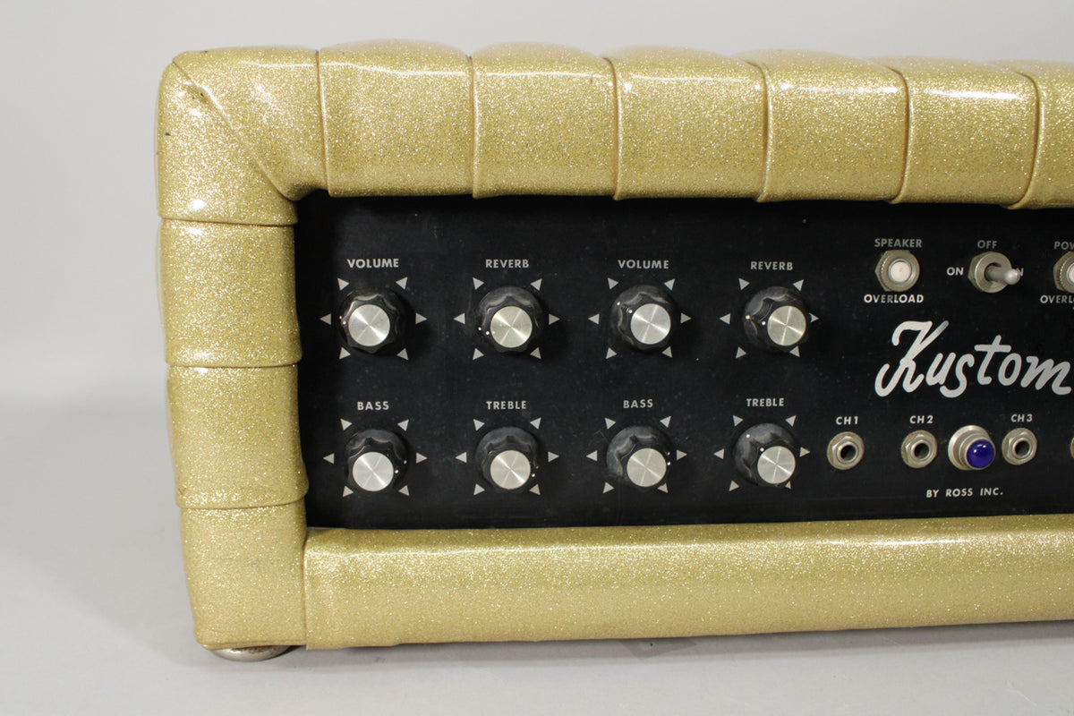 The gold sparkle PA head is angled from the left, showing the black control panel with two rows of knobs and input jacks.